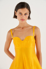 Profile view of model wearing the Oroton Sculpture Bodice Dress in Marigold and 86% Polyester, 14% Silk for Women