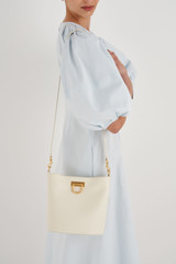 Profile view of model wearing the Oroton Colt Bucket in Clotted Cream and Smooth Leather for Women