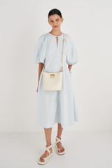 Profile view of model wearing the Oroton Colt Bucket in Clotted Cream and Smooth Leather for Women