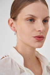 Profile view of model wearing the Accessories Wrenley Hoops in Silver and Brass Base Metal With Rhodium Plating for Women