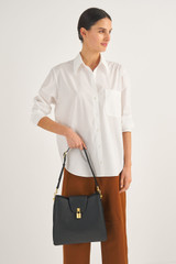 Profile view of model wearing the Oroton Tate Hobo in Black and Pebble Leather for Women