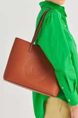 Profile view of model wearing the Oroton Polly Medium Tote in Cognac and Pebble Leather for Women