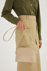 Profile view of model wearing the Oroton Inez Slim Crossbody in Fawn and Smooth Saffiano for Women . IP:4