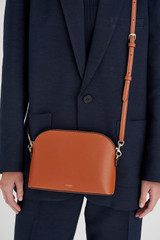 Profile view of model wearing the Oroton Inez Slim Crossbody in Cognac and Shiny Soft Saffiano for Women . IP:3