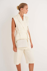 Profile view of model wearing the Oroton Inez Slim Crossbody in Cream and Saffiano Leather for Women . IP:3