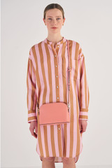 Profile view of model wearing the Oroton Inez Slim Crossbody in Pink Clay and Shiny Soft Saffiano for Women