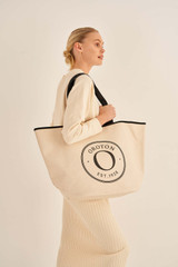 Profile view of model wearing the Oroton Kaia Shopper Tote in Natural/Black and Coated canvas material for Women . IP:2