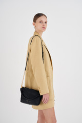 Profile view of model wearing the Oroton Lilly Zip Top Crossbody in Black and Pebble leather for Women