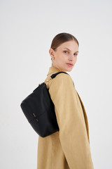 Profile view of model wearing the Oroton Lilly Zip Top Crossbody in Black and Pebble leather for Women