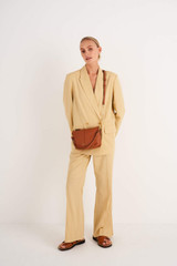 Profile view of model wearing the Oroton Lilly Zip Top Crossbody in Cognac and Pebble leather for Women