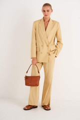 Profile view of model wearing the Oroton Lilly Zip Top Crossbody in Cognac and Pebble leather for Women