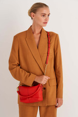 Profile view of model wearing the Oroton Lilly Zip Top Crossbody in Crimson and Pebble leather for Women