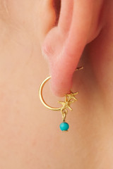 Profile view of model wearing the Oroton Starfish Charm Hoops in Worn Gold/Turquoise and Brass base metal with precious metal plating for Women