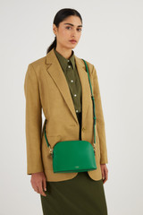 Profile view of model wearing the Oroton Inez Slim Crossbody in Emerald and Shiny Soft Saffiano for Women