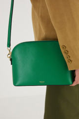 Profile view of model wearing the Oroton Inez Slim Crossbody in Emerald and Shiny Soft Saffiano for Women