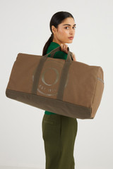 Profile view of model wearing the Oroton Kane Weekender in Khaki and Recycled Canvas for Women