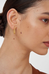 Profile view of model wearing the Oroton Hadley Huggies in Worn Gold and Brass Base With 18CT Gold Plating for Women
