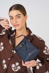 Profile view of model wearing the Oroton Margot Tiny Bucket Bag in North Sea and Pebble leather for Women . IP:2