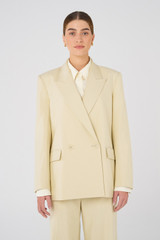 Profile view of model wearing the Oroton Blazer in Almond and 58% Viscose, 42% Cotton for Women