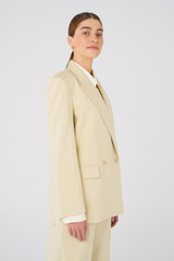 Profile view of model wearing the Oroton Blazer in Almond and 58% Viscose, 42% Cotton for Women