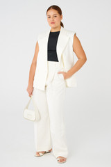 Profile view of model wearing the Oroton PLEAT SLOUCH PANT in Cream and 58% viscose, 42% linen for Women