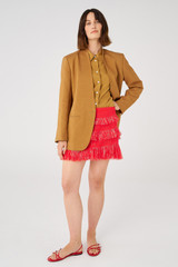 Profile view of model wearing the Oroton Fringed Mini Skirt in Poppy and 22.4% polyamide, 28% acrylic, 49.5% polyester for Women