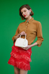 Profile view of model wearing the Oroton Fringed Mini Skirt in Poppy and 22.4% polyamide, 28% acrylic, 49.5% polyester for Women