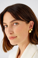 Profile view of model wearing the Oroton Josie Huggies in 18K Gold and Sterling silver for Women .