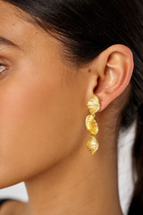 Profile view of model wearing the Oroton Conch Drop Earrings in Worn Gold and Brass for Women