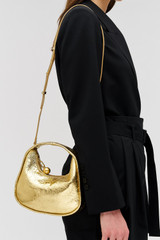 Profile view of model wearing the Oroton Clara Mini Bag in Gold and Metallic crinkle leather for Women . IP:4