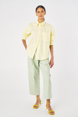 Profile view of model wearing the Oroton Poplin Long Sleeve Shirt in Lemon Curd and 100% cotton for Women