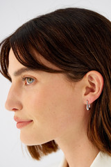 Profile view of model wearing the Oroton Kora Mini Hoops in Silver and Sustainably sourced 925 Sterling Silver for Women . IP:2