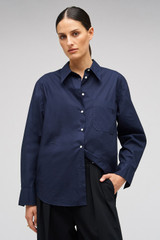 Profile view of model wearing the Oroton Poplin Long Sleeve Shirt in North Sea and 100% cotton for Women