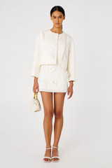 Profile view of model wearing the Oroton Crop Jacket in Cream and 58% Viscose, 42% Linen for Women