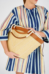 Profile view of model wearing the Oroton Callaway Straw Tote in Natural/Amber and Woven straw with leather trims for Women