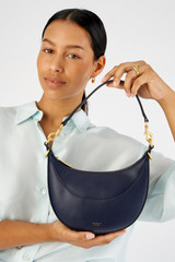 Profile view of model wearing the Oroton Florence Small Shoulder Bag in North Sea and Premium smooth leather for Women . IP:2
