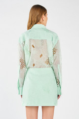 Profile view of model wearing the Oroton Lace Mini Skirt in Sea Spray and 100% polyester for Women . IP:5