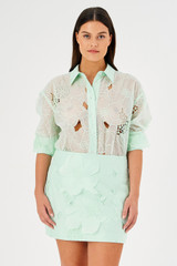 Profile view of model wearing the Oroton Lace Mini Skirt in Sea Spray and 100% polyester for Women .