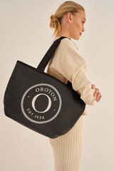 Profile view of model wearing the Oroton Kaia Mini Shopper Tote in Black and Coated Canvas for Women . IP:3