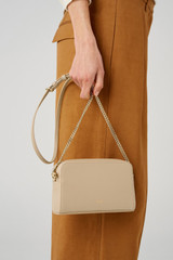 Profile view of model wearing the Oroton Inez Chain Crossbody in Fawn and Smooth Saffiano for Women
