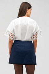 Profile view of model wearing the Oroton Contrast Bind Double Breasted Mini Skirt in North Sea and 100% linen for Women