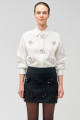 Profile view of model wearing the Oroton Flower Sequin Mini Skirt in Black and 100% linen for Women