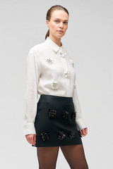 Profile view of model wearing the Oroton Flower Sequin Mini Skirt in Black and 100% linen for Women