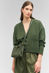 Profile view of model wearing the Oroton Margot Tiny Bucket Bag in Moss and Pebble leather for Women . IP:3