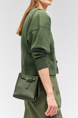 Profile view of model wearing the Oroton Margot Tiny Bucket Bag in Moss and Pebble leather for Women . IP:2