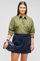Profile view of model wearing the Oroton Mini Trouser Skirt in North Sea and 98%  wool, 2% elastane for Women