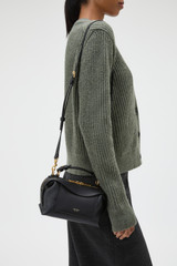 Profile view of model wearing the Oroton Mica Mini Bowler in Black and Premium pebble leather for Women . IP:2