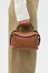 Profile view of model wearing the Oroton Mica Mini Bowler in Brandy and Premium pebble leather for Women . IP:3