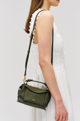 Profile view of model wearing the Oroton Mica Mini Bowler in Dark Khaki and Premium pebble leather for Women . IP:4