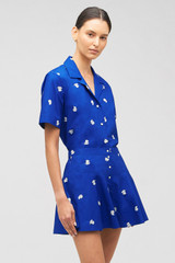 Profile view of model wearing the Oroton Embroidered Fruit Skort in Azure Blue and 100% cotton for Women